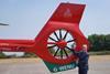 Ascona Group CEO Darren Briggs alongside Branded Wales Air Ambulance Helicopter